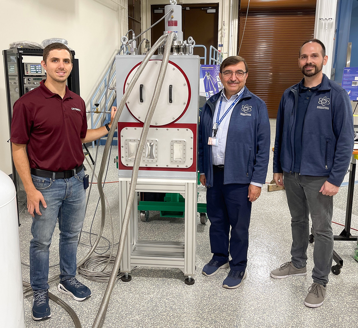 Tim Hanrahan, Dr. Kenan Ünlü and Daniel Beck with the Penn State’s new Cryomech cryostat designed to enable small-angle neutron scattering.
